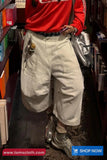 Person wearing a red jacket and beige cargo pants in a bookstore setting.