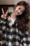 Woman wearing a plaid coat with a neutral background