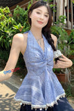 Woman wearing a blue dress with white lace details outdoors.