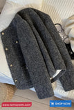 Gray coat with gold buttons on a textured surface, brand 'TomsCloth' visible.