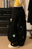 Person wearing black pants with colorful patches in a room setting.