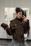 Person wearing a brown jacket taking a mirror selfie in a tiled bathroom.