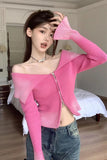 Woman wearing a pink off-shoulder top and blue jeans in a bedroom setting