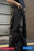 Person wearing dark denim cargo pants with a brick wall background