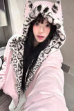 Person wearing a pink hoodie with leopard print hood in an indoor setting