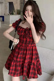 Woman wearing a red plaid dress in an indoor setting