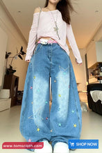 Person wearing a striped top and wide-leg jeans with star patterns in a room.