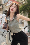 Woman holding a coffee cup and a bag, standing outdoors with a building and bicycle in the background.