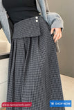 Person wearing a gray checkered skirt with a blurred background