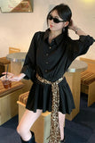 Woman in a black outfit with a leopard print skirt in a cafe setting