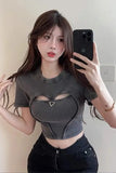 Person wearing a dark gray crop top with cut-out design, taking a mirror selfie.