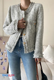 Person wearing a textured gray jacket with button details, standing indoors.