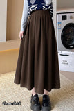 Person wearing a brown skirt in front of a washing machine.