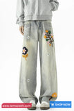 Light gray jeans with colorful floral embroidery on a white background