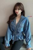 Person wearing a blue denim jacket against a plain background