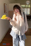 Person holding a plate of fruit in a room with a window and furniture.