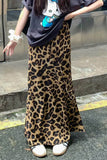 Person wearing a leopard print skirt on a city street.