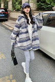 Woman wearing a blue and white striped coat on a street.