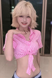 Person wearing a pink checkered top with a blurred background