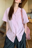 Person wearing a light purple shirt and dark pants in an indoor setting