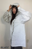 Person wearing a striped shirt with a hood against a plain background