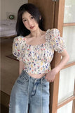 Woman wearing a floral blouse and jeans indoors