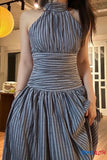 Woman wearing a blue and white striped dress indoors.