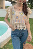 Person wearing a colorful crochet top and blue jeans by a poolside.