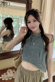 Woman posing indoors with a mirror reflection, wearing a denim top and beige skirt.