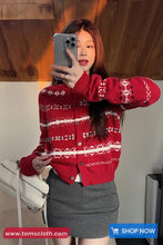 Person wearing a red patterned cardigan taking a mirror selfie.