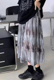 Person wearing a patterned skirt and black shoes in an indoor setting