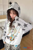 Person wearing a gray hoodie with star patterns and a white shirt with cartoon designs.