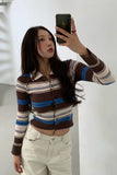 Person wearing a striped sweater taking a mirror selfie.