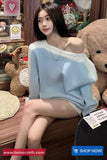 Woman in a light blue sweater sitting in a store with teddy bears in the background