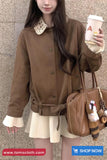 Woman in a brown coat holding a coffee cup and a handbag with a 'Shop Now' button visible.