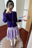 Person wearing a purple cardigan and polka dot skirt in a room with a wooden floor and white walls.