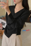 Person wearing a black oversized blazer and beige pants, taking a selfie.