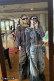 Two people taking a mirror selfie in a casual setting with 'Tomscloth' branding.