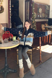 Person sitting at a table in a cozy indoor setting with a festive atmosphere