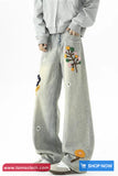 Light gray pants with colorful floral embroidery on a white background