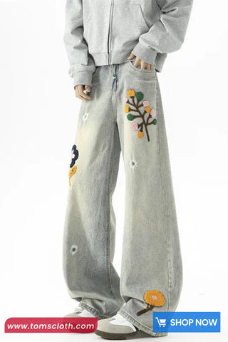 Light gray pants with colorful floral embroidery on a white background