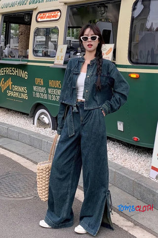 Woman in denim outfit standing in front of a vintage green bus, with 'Tom & Cloth' branding visible.
