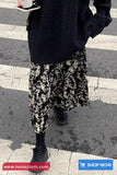Person wearing a dark sweater and patterned pants on a zebra crossing with 'tomscloth.com' branding.
