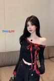 Woman wearing a black top with red accents in a room with a couch.