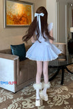 Person wearing a white dress with a bow in a living room setting