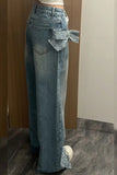 Person wearing blue jeans with a belt in a room with a wooden floor and white wall.