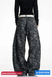 Person wearing black camouflage pants on a white background with 'tomscloth.com' branding.
