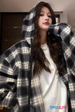 Person wearing a plaid hoodie with a blurred background