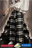Person wearing a gray hoodie and plaid pants walking down a staircase.