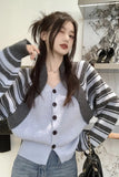 Woman wearing a striped cardigan over a button-up shirt with a blurred background